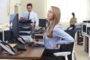 49359621 - businesswoman working at desk suffering from backache