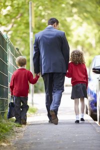 30999994 - father walking to school with children on way to work